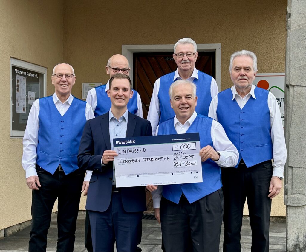 5 Sänger des Männerchor Liederkranz Straßdorf stehen in Chorkleidung mit einem Vertreter der BW Bank vor dem Rathaus